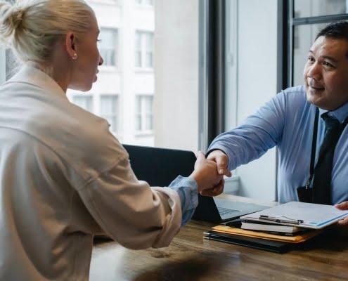 ethnic businessman shaking hand of applicant in office